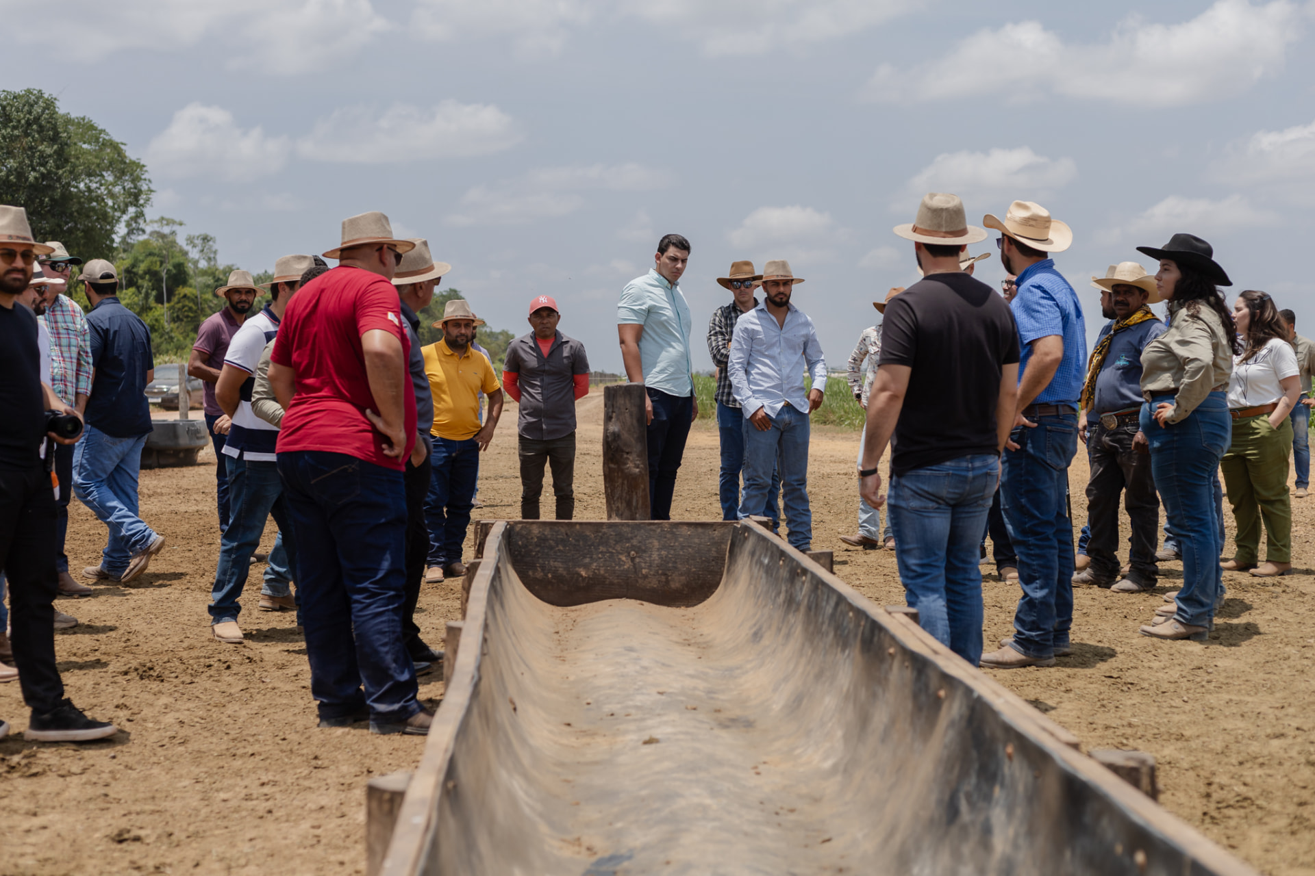 Participantes reunidos em volta do cocho no pasto irrigado